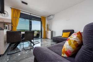 a living room with a couch and a table with yellow curtains at Villa Blue Sky 1 in Turanj