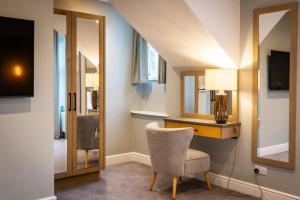 a room with a chair and a desk with a mirror at Ambleside Fell Rooms in Ambleside