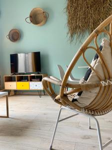 uma cadeira de vime numa sala de estar em Appartement de standing avec terrasse em Saintes-Maries-de-la-Mer