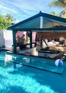 a swimming pool with a gazebo on top of it at THUISHAVEN boutique mini-resort - fantastic garden and large pool - adults only in Willemstad