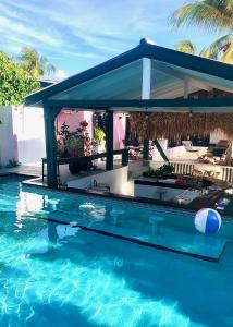 een zwembad met een prieel erop bij THUISHAVEN boutique mini-resort - fantastic garden and large pool - adults only in Willemstad