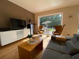 a living room with a couch and a tv at Eifel-Mosel-Hideaway in Landscheid
