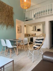 a living room with a dining table and chairs at Appartement de standing avec terrasse in Saintes-Maries-de-la-Mer