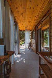 um corredor de uma casa com tecto de madeira em Pousada Canto da Nascente em Monte Verde
