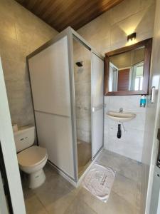 a bathroom with a shower and a toilet and a sink at AVANI Boutique Hotel in Norcasia