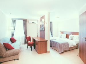 サマラにあるBoutique Hotel Countriesのベッド、デスク、椅子が備わるホテルルームです。