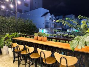 a table and chairs on a balcony with plants at BÊ TÔNG RESIDENCES HOMESTAY in Can Tho