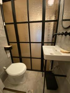 y baño con aseo y lavamanos. en Charming apartment in the heart of Gellért area., en Budapest