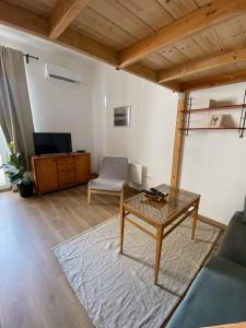 a living room with a table and a couch and a tv at Charming apartment in the heart of Gellért area. in Budapest