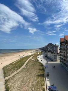 uma vista para uma praia com pessoas e para o oceano em Sfeervol Appartement met Zeezicht em Middelkerke