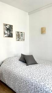 Chez Clément et Mathilde - Studio hyper centre tout équipé في سانت أماند ليه أوكس: غرفة نوم بسرير وصورتين على الحائط
