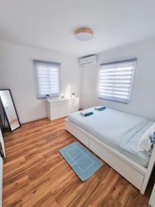 um quarto com uma cama e piso em madeira em ביקתה בים em Tel Aviv