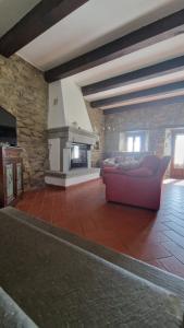 un salon avec un canapé et une cheminée dans l'établissement La Sala Vecchia - Lovely Tuscan Holiday house Badia Prataglia, Casentino Valley, à Chiusi della Verna