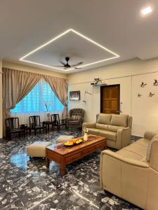 uma sala de estar com sofás e uma mesa de centro em Lasam Heritage Villa + Glamping in the House 24pax with Karaoke & Snooker em Ipoh