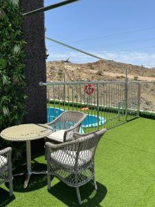 un patio con 2 sillas, una mesa y una piscina en فندق ذكرى الكوثر en Taif