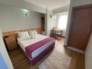 a bedroom with a bed and a table and a door at HOTEL ÖZSEFA in Istanbul