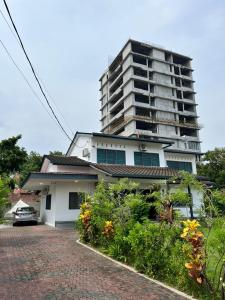 um edifício de apartamentos alto em frente a uma casa em Lasam Heritage Villa + Glamping in the House 24pax with Karaoke & Snooker em Ipoh