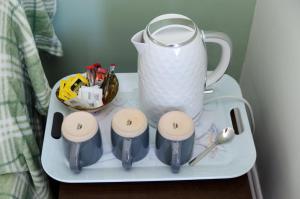 eine Teekanne und vier Tassen auf einem Tablett in der Unterkunft The Waterside in Redcar