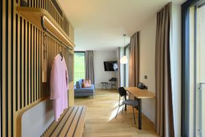 a hotel room with a pink robe hanging on a wall at Stoos Lodge in Stoos