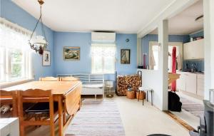 een keuken en eetkamer met blauwe muren en een tafel bij Stunning Home In Vinslv With Kitchen in Vinslöv