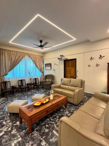 uma sala de estar com um sofá e uma mesa em Lasam Heritage Villa + Glamping in the House 24pax with Karaoke & Snooker em Ipoh