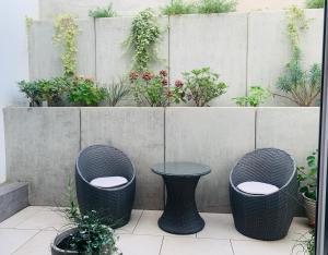 a patio with three wicker chairs and a table at Ferienwohnung-Weinstadt UG in Weinstadt