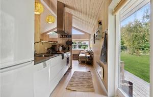 uma cozinha com armários brancos e uma grande janela em 3 Bedroom Lovely Home In Kalundborg em Kalundborg