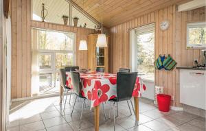 HelberskovにあるBeautiful Home In Hadsund With House Sea Viewのダイニングルーム(赤と白のテーブル、椅子付)