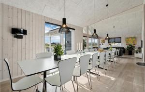 uma sala de jantar com uma mesa longa e cadeiras em Amazing Home In Hvide Sande With 9 Bedrooms, Sauna And Indoor Swimming Pool em Havrvig