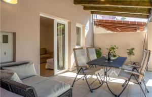 a patio with a table and chairs and a couch at 3 Bedroom Stunning Home In Barbat in Barbat na Rabu