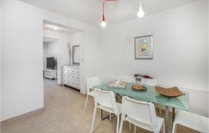 a dining room with a blue table and white chairs at 3 Bedroom Stunning Home In Barbat in Barbat na Rabu