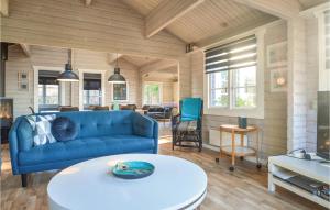 salon z niebieską kanapą i stołem w obiekcie Gorgeous Home In Hjrring With Ethernet Internet w mieście Lønstrup