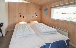 GrønhøjにあるGorgeous Home In Lkken With Kitchenのウッドウォールと窓が備わるドミトリールームのベッド2台分です。