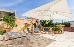 patio con tavolo e ombrellone bianco di 2 Bedroom Cozy Home In Vitigliano a Vitigliano