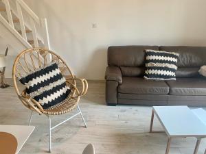a living room with a couch and a chair at Appartement de standing avec terrasse in Saintes-Maries-de-la-Mer