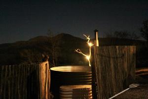 une clôture avec un seau et une lumière dans l'obscurité dans l'établissement Tugela River Lodge, à Winterton