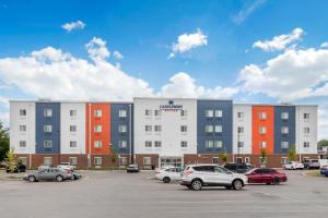 a parking lot with cars parked in front of a building at Candlewood Suites Indianapolis East by IHG in Indianapolis