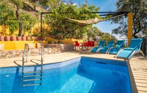 a swimming pool with blue chairs and a table at Amazing Cottage In Algatocn With Kitchen in Algatocín