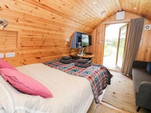 a bedroom with a large bed in a log cabin at Conwy Pod in Llanrwst