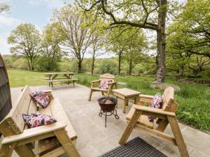 a patio with benches and picnic tables in a park at Conwy Pod in Llanrwst