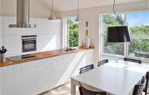 ロッケンにあるBeautiful Home In Lkken With Wifiのキッチン(白いカウンター、テーブル、椅子付)