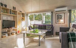 HelberskovにあるAmazing Home In Hadsund With 4 Bedrooms, Sauna And Wifiのリビングルーム(ソファ、テーブル付)