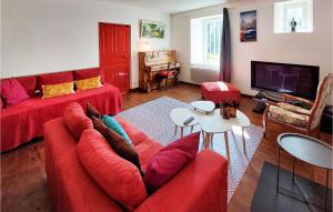 een woonkamer met een rode bank en een tv bij 6 Bedroom Lovely Home In Trguier in Tréguier