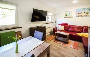 a living room with a red couch and a tv at Stunning Home In Nahetal-waldau With Sauna in Hinternah