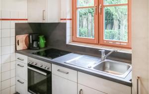 a kitchen with a sink and a stove and window at Awesome Apartment In Prerow With Kitchen in Prerow