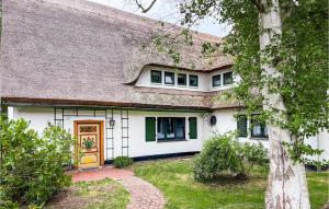 a white house with a brown door and a tree at Awesome Apartment In Prerow With Kitchen in Prerow