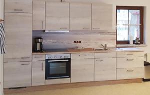 Una cocina con gabinetes blancos y un horno. en 3 Bedroom Pet Friendly Home In Prerow, en Prerow