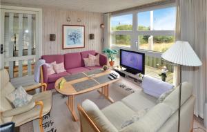 Grønhøjにある3 Bedroom Cozy Home In Lkkenの紫色のソファとテーブル付きのリビングルーム