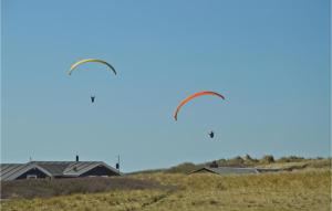 dos cometas volando en el cielo sobre un campo en Awesome Home In Lkken With 4 Bedrooms, Sauna And Wifi, en Lønstrup