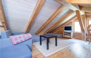 HelberskovにあるAwesome Home In Hadsund With 3 Bedrooms, Sauna And Wifiのリビングルーム(青いソファ、テレビ付)